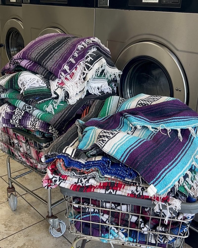 Striped woven blankets piled on laundry carts