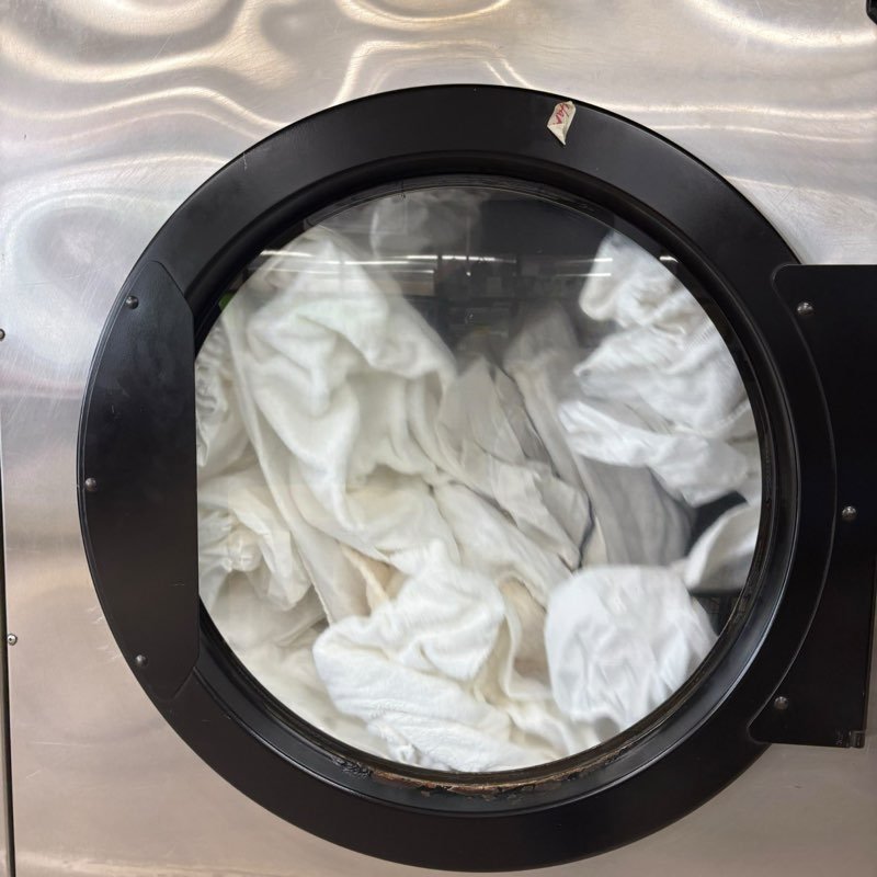 White laundry tumbling in a commercial dryer