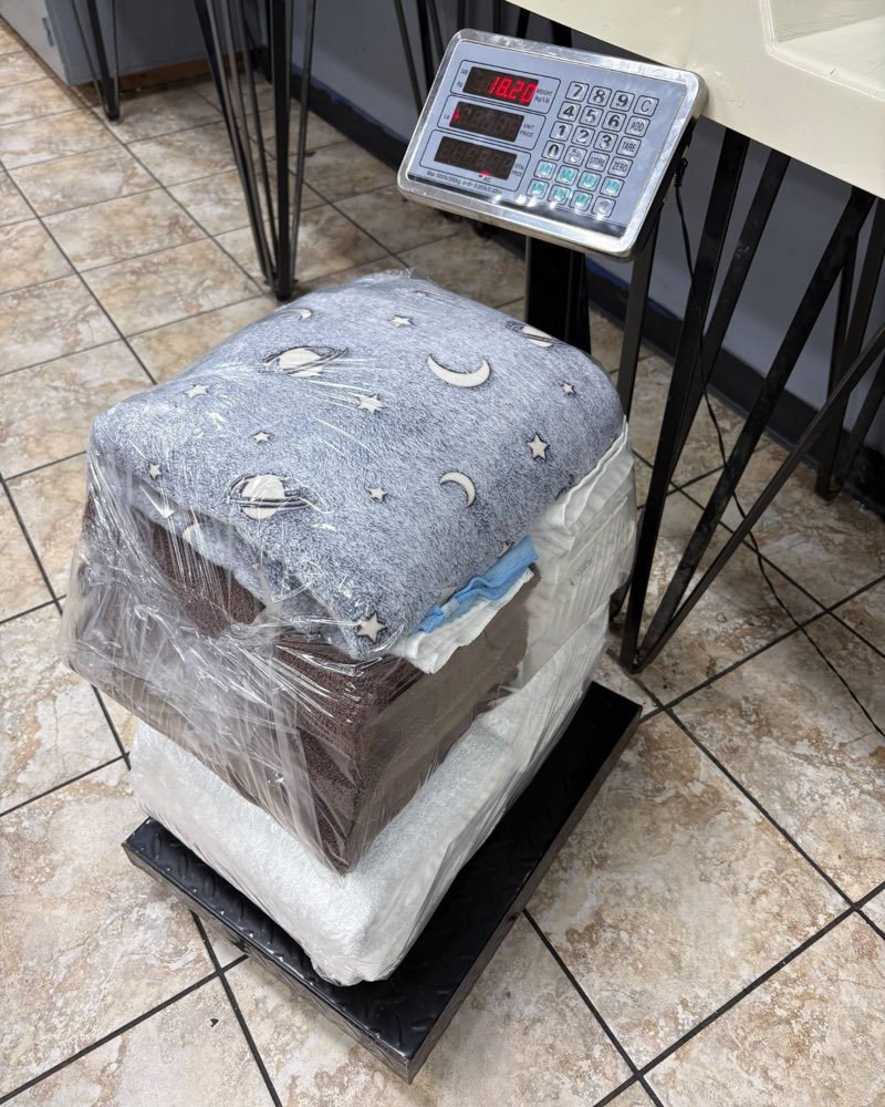 A wrapped laundry order being weighed on a digital scale