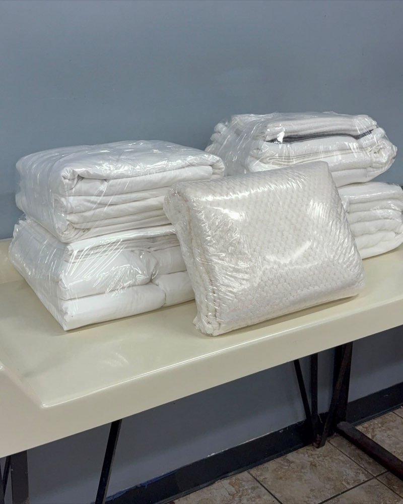 Comforters and blankets folded and wrapped in plastic